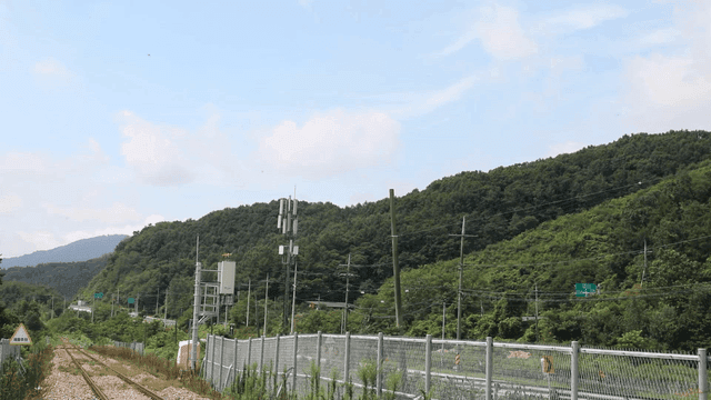 Railroad tracks beside lush green mountains