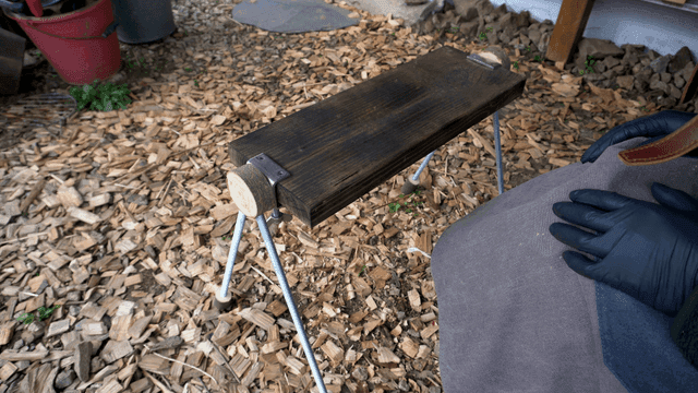 수제 나무 벤치를 만져보는 목공예가