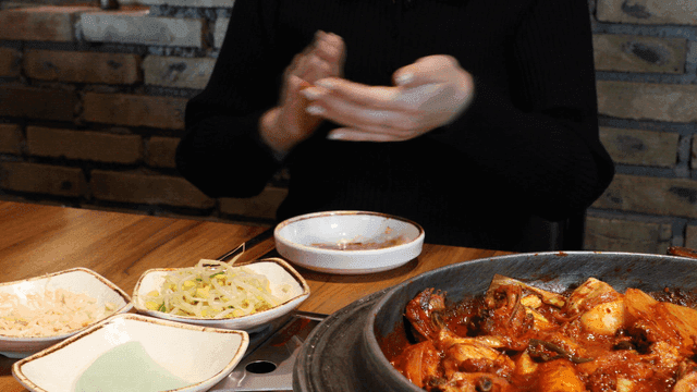 Person clapping while eating spicy chicken jjagal