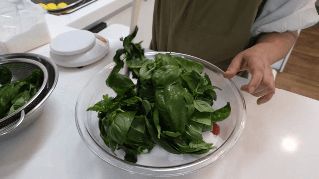 주방에서 신선한 바질 잎을 섞는 모습
