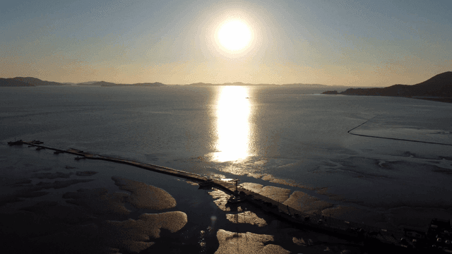 Sunset over a calm sea with distant islands