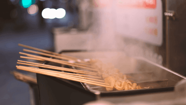 Sight of fish cake skewers steaming and cooking at night