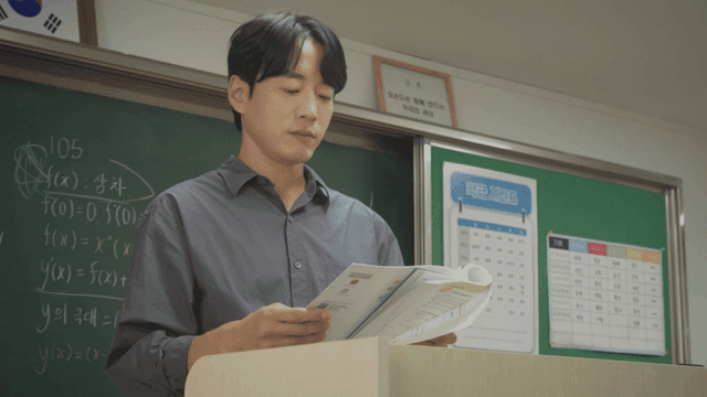 Teacher explaining while looking at a workbook