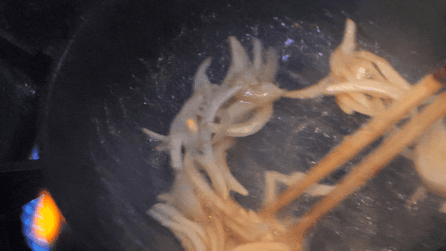 Onions being sautéed in a pan