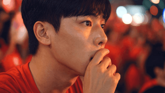 Man in red T-shirt looking intently