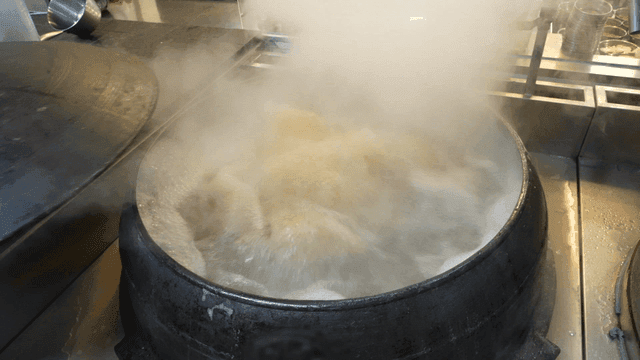 Scene of opening lid of boiling cauldron