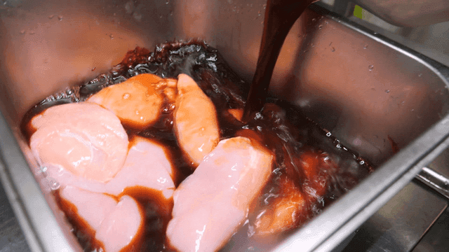 Rich sauce poured over raw chicken