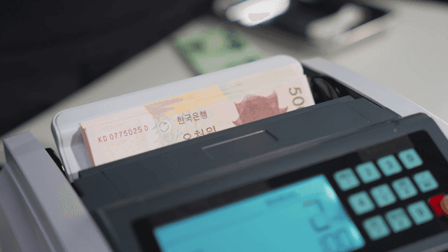 기계에서 한국 원화를 세는 모습