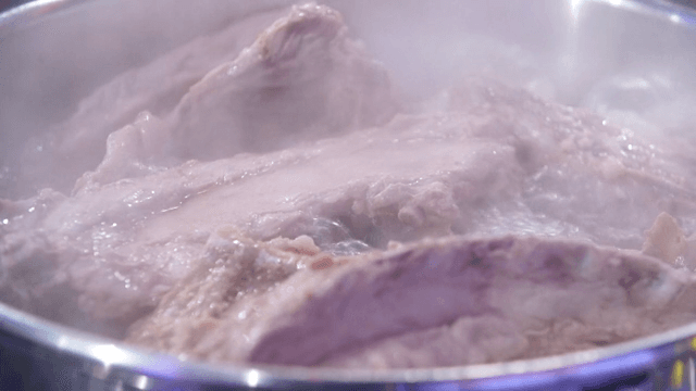 Pork backbones boiling in a large pot