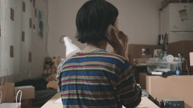 어수선한 방에서 전화하는 사람