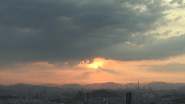 극적인 구름과 함께 해질녘 도시 스카이라인