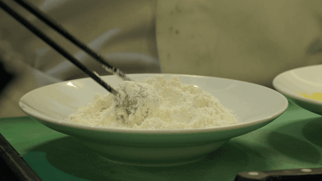 Scene of dipping round meat in flour with chopsticks