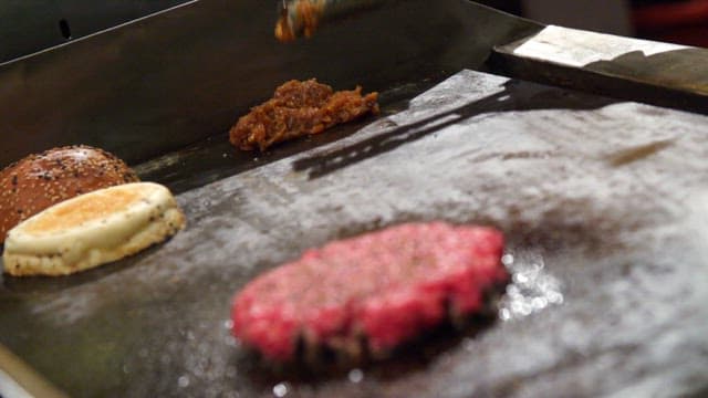 Burger ingredients cooking on a grill