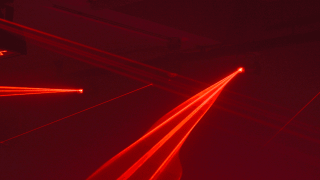 Vivid red laser beams on dark stage