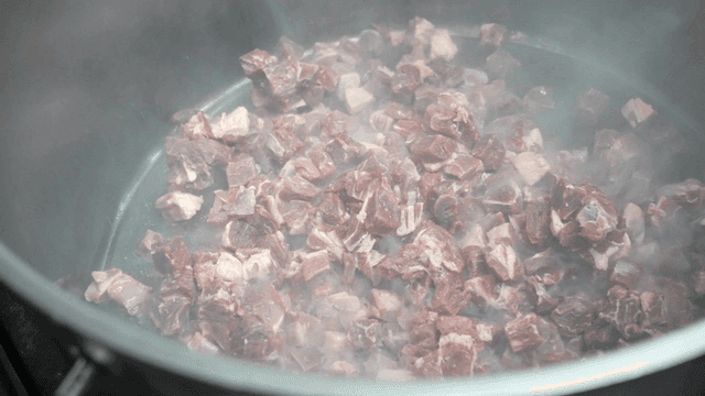 Chunks of meat boiling in a pot