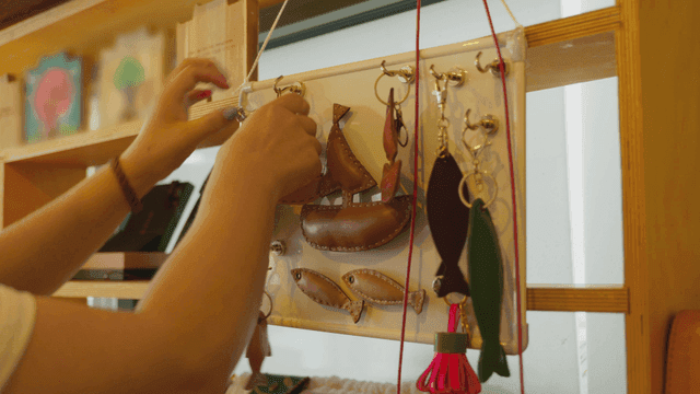 수제 가죽 열쇠고리를 진열하는 손