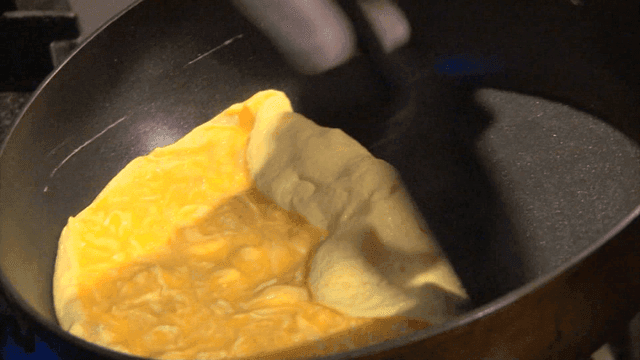 Moist omelette rolling on frying pan