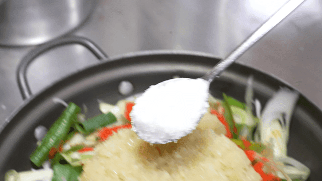 Salt placed on pot topped with sweet garlic and green onions