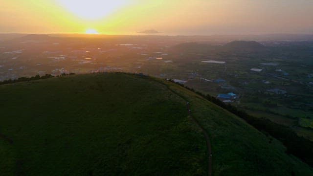 언덕 정상에서 경치 좋은 석양을 바라보는 사람들