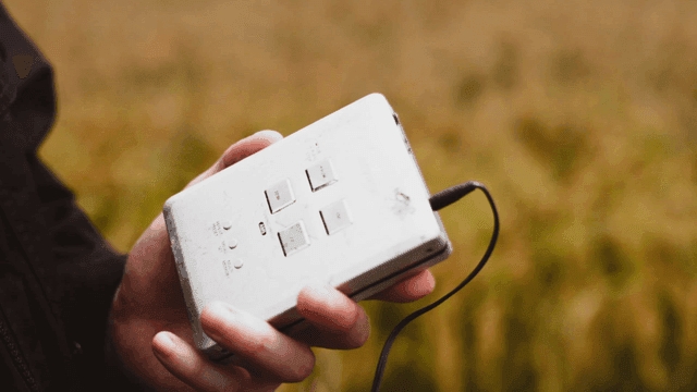 Person holding audio player in field