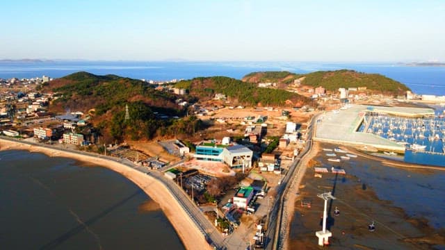 Aerial view of a coastal town surrounded by hills and sea