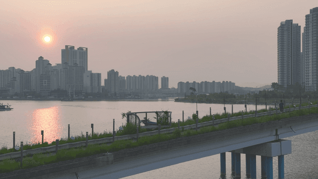 Sunset over a river with city skyline