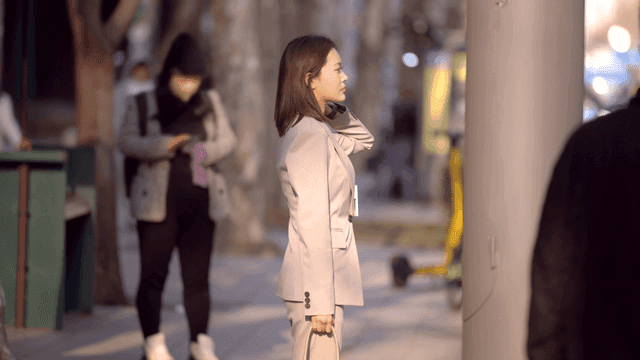 Side view of female office worker in suit standing on street