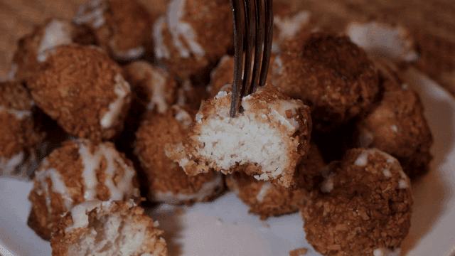 Fork dipped in coconut rocher on plate