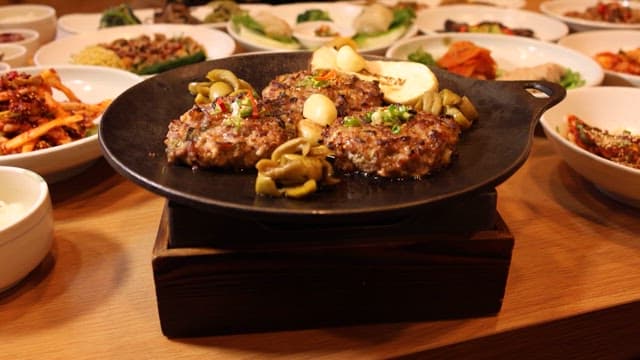 다양한 반찬과 함께 차려진 육즙 가득한 떡갈비