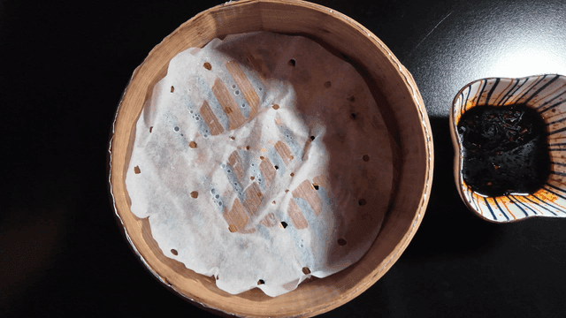 Empty bamboo steamer and soy sauce on table