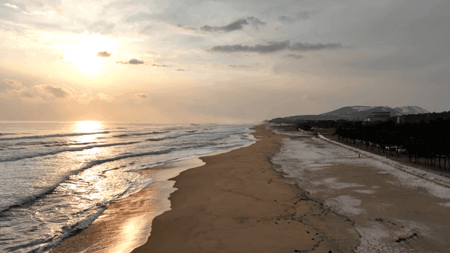 Serene beach with waves at sunrise