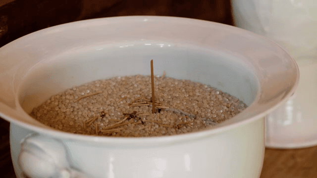 흰색 도자기 그릇에 담긴 쌀과 향 스틱