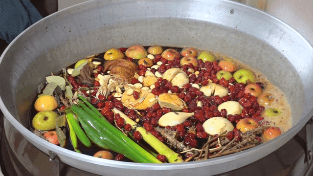 A large pot with various herbs and fruits