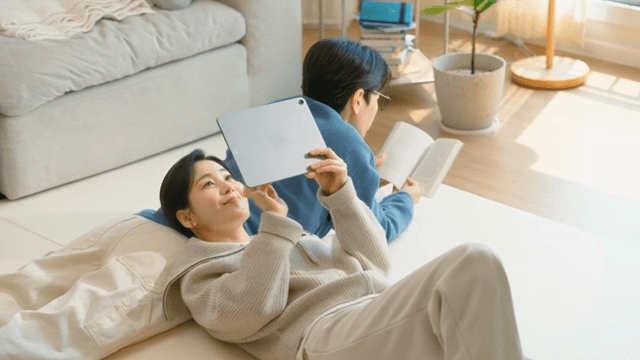 책과 태블릿을 들고 집에서 휴식 중인 부부