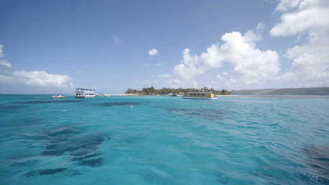 맑은 바다에 떠 있는 열대 섬과 보트