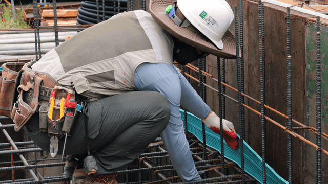 건설 현장에서 파이프를 고정하는 작업자