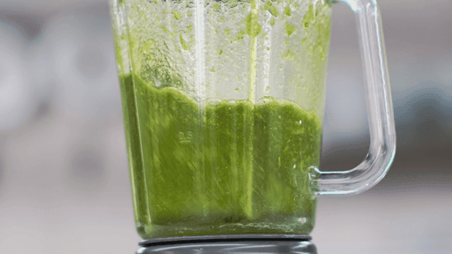 유리 믹서기에서 블렌딩되는 녹색 스무디