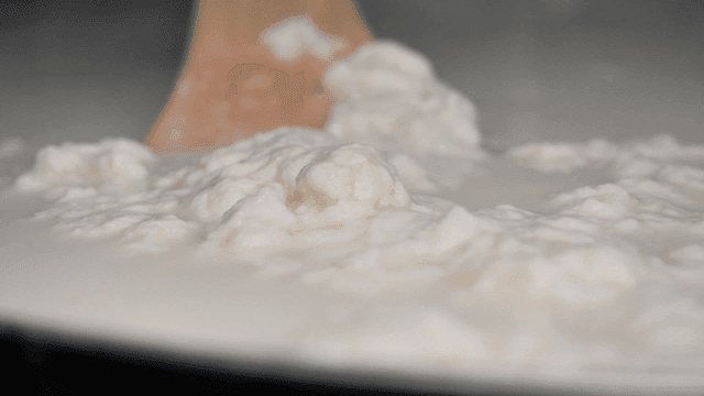 Sundubu (soft tofu) stirred with wooden spoon in pot