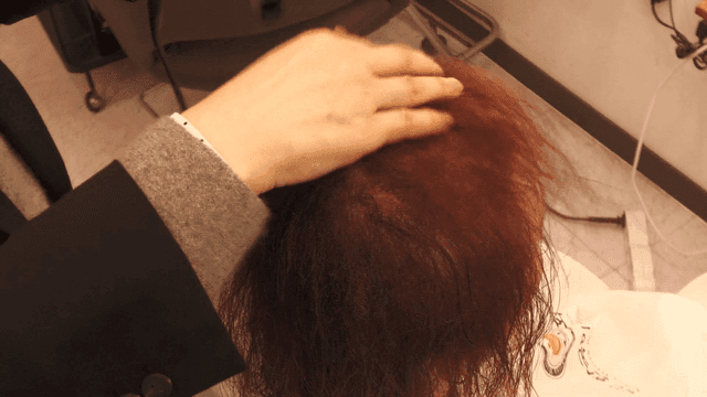 Hairdresser styling hair with dryer