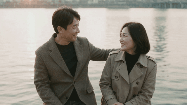 Middle-aged couple sitting by river