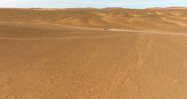 Vehicle traveling through a vast desert