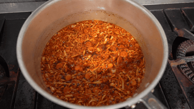 Scallion and chili oil heating on stove flame