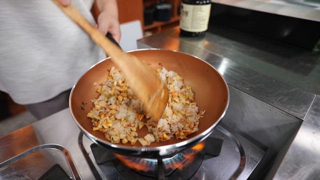 Stir-fried rice with eggs and vegetables in a skillet on the stove