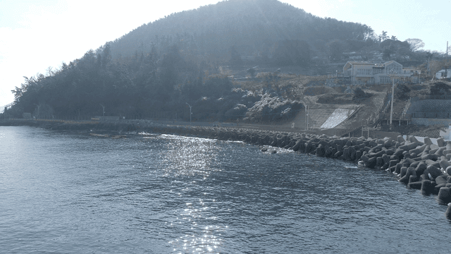 산을 배경으로 한 방파제와 바다