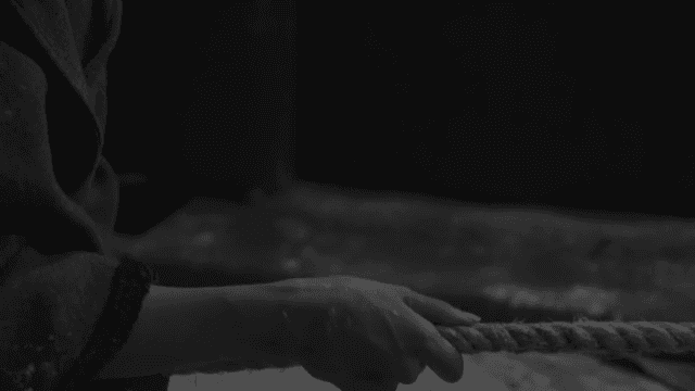 떨리는 손으로 밧줄을 잡아당기는 손