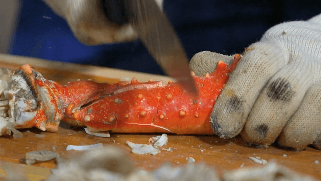 나무 도마 위에서 게 다리 자르기