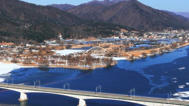 Winter Landscape with Bridge Over Partially Frozen River