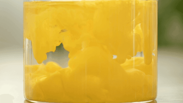 Yellow dye dispersing in clear water