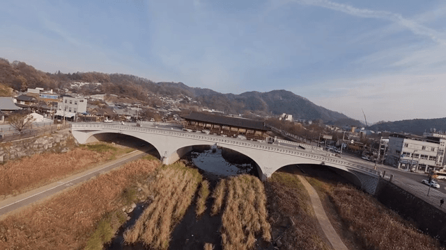 강 위의 다리에 위치한 한옥 정자