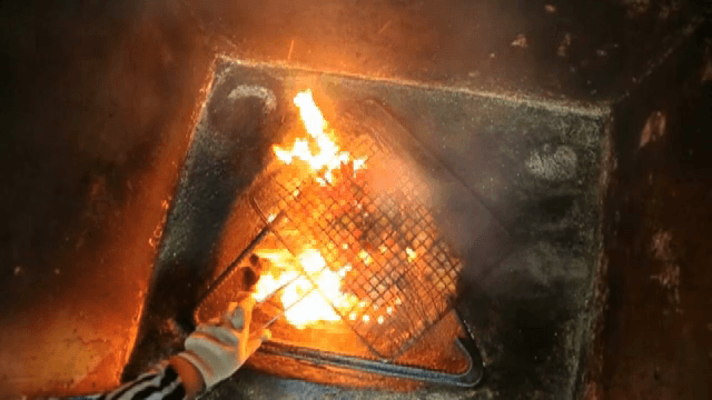 Grilling marinated meat over open flames